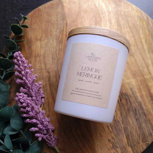 Lemon Meringue Candle with zesty lemon, creamy coconut, and vanilla scent on a wooden surface.