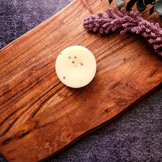 Vegan-friendly Glow Waxmelt on wooden surface with star accents.