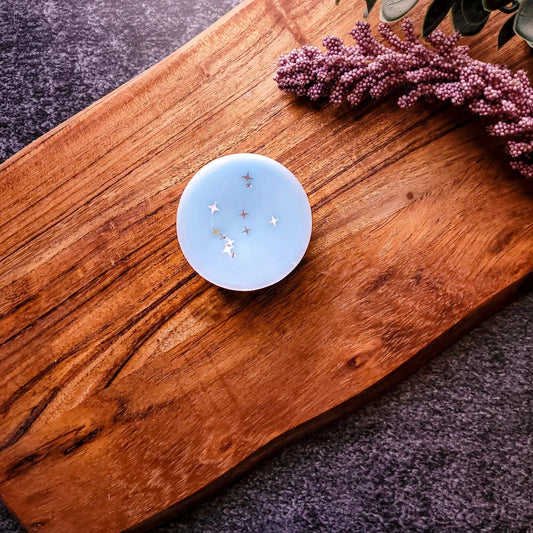 Blue Meditate waxmelt on wooden tray, adorned with decorative stars, promoting relaxation and wellness.