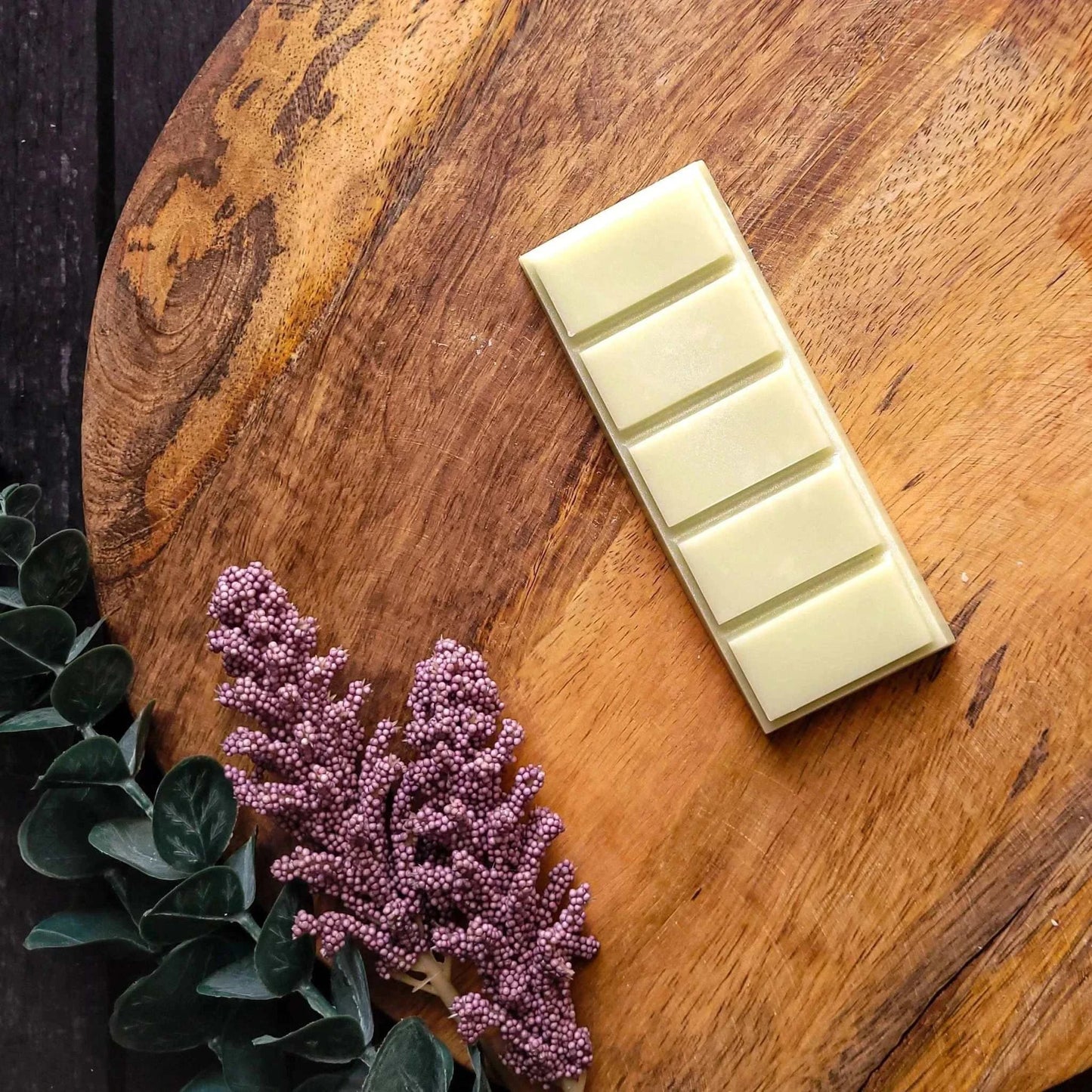 Vegan-friendly Manifest Waxmelt in wellness range on wooden surface with foliage.