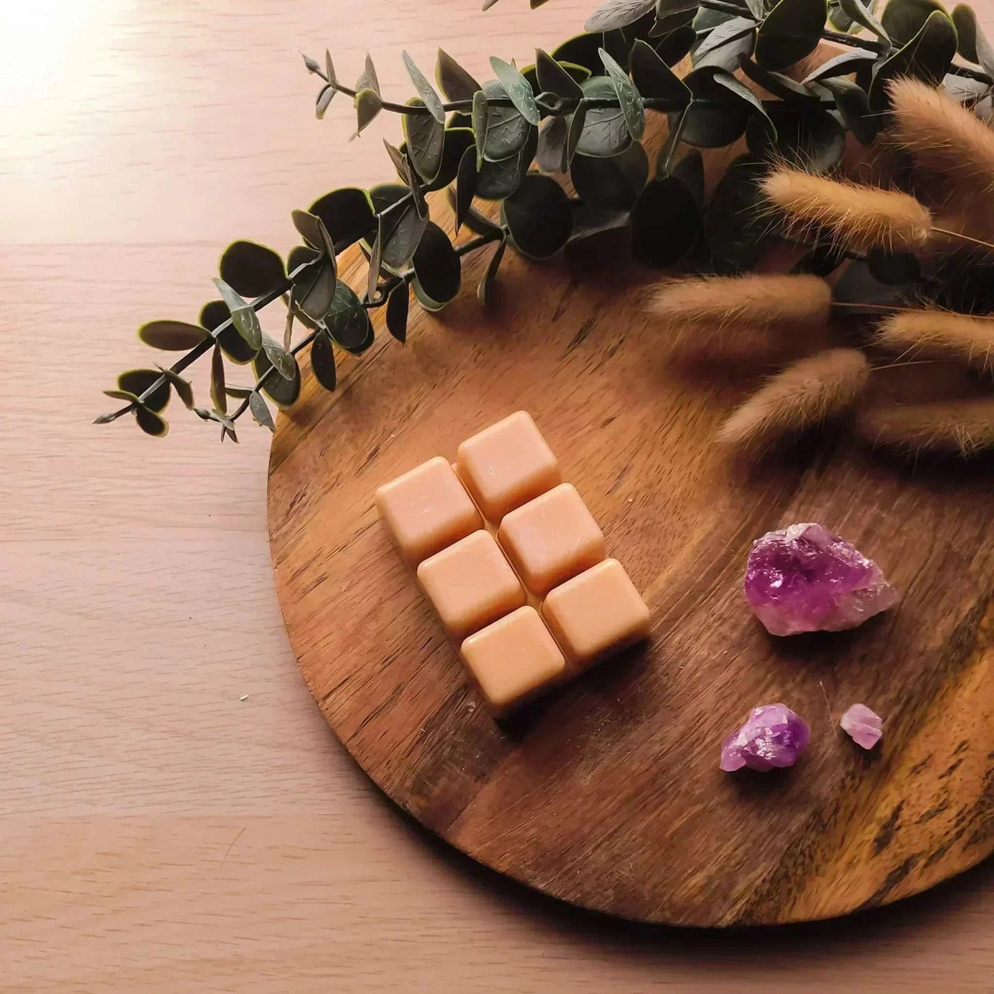 Vegan-friendly soy wax melt pack with purple crystals on wooden board, eco-inspired ambiance.