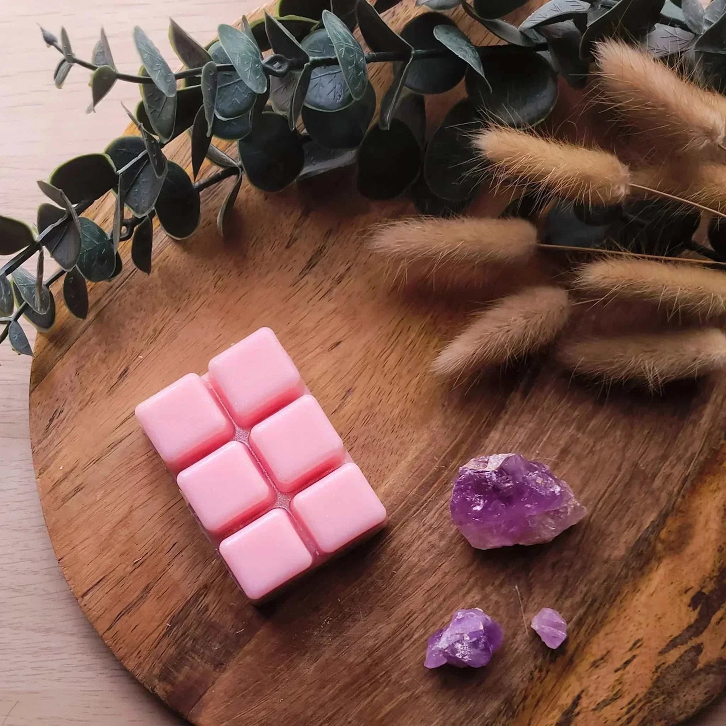 Vegan-friendly soy wax melt pack, 80g, pink cubes, on wooden surface with greenery.
