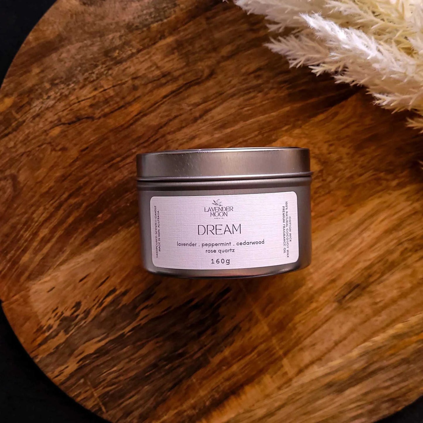 Dream Candle tin with lavender, mint, and cedarwood blend, surrounded by soft decor.