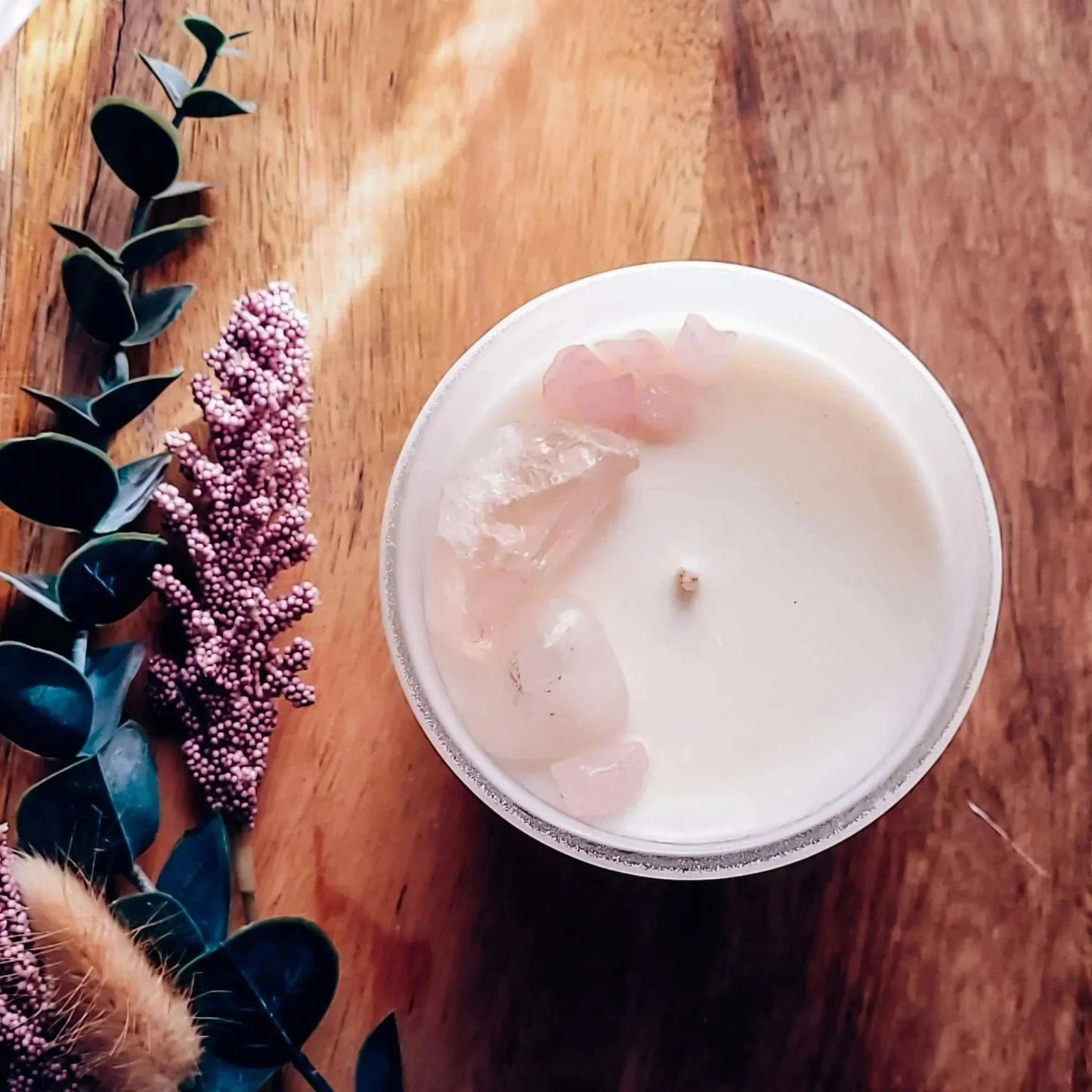 Dream Candle with lavender, mint, and cedarwood scent, featuring Rose Quartz crystals on a wooden surface.