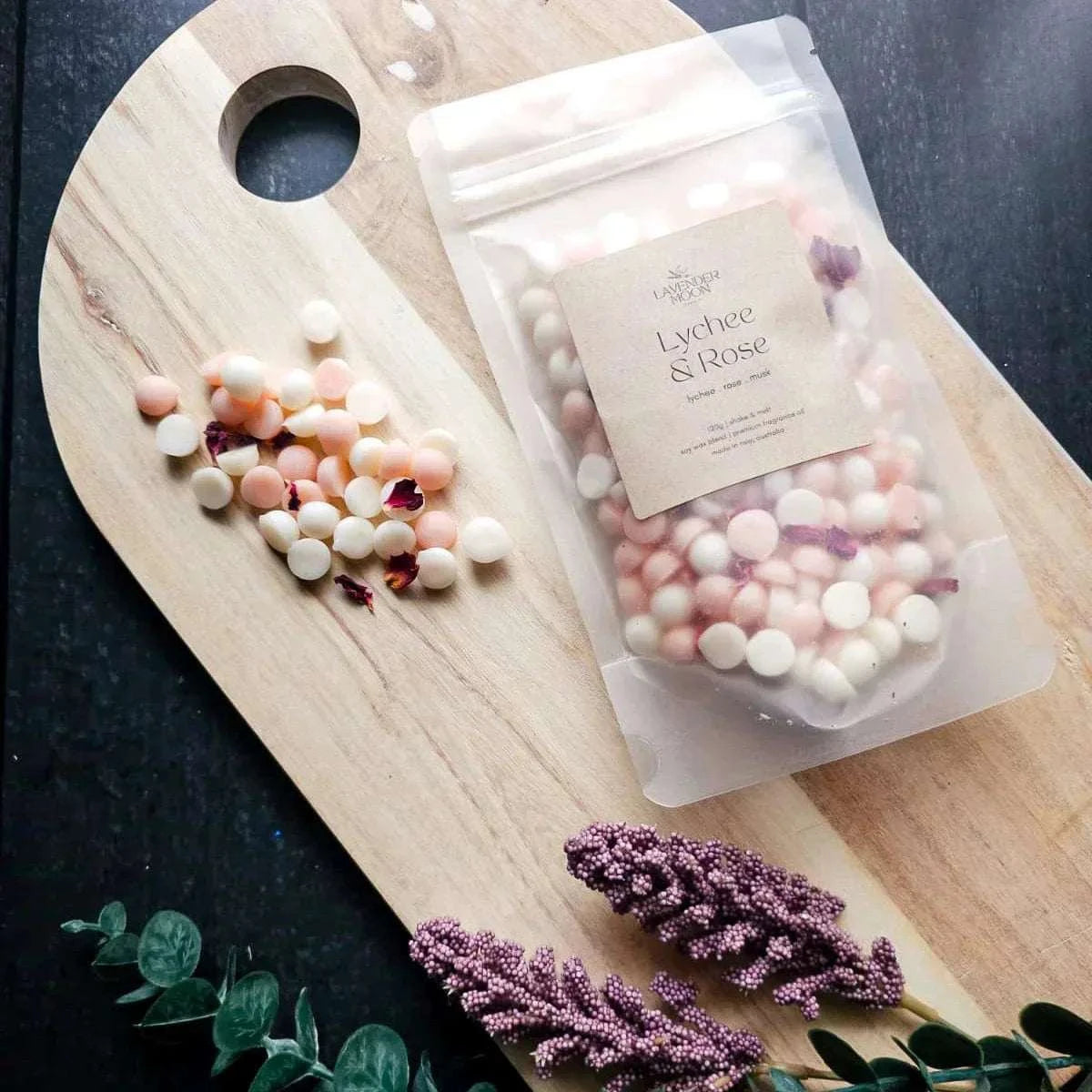Lychee & Rose Waxmelt with lychee, rose, and musk scents on a wooden board.