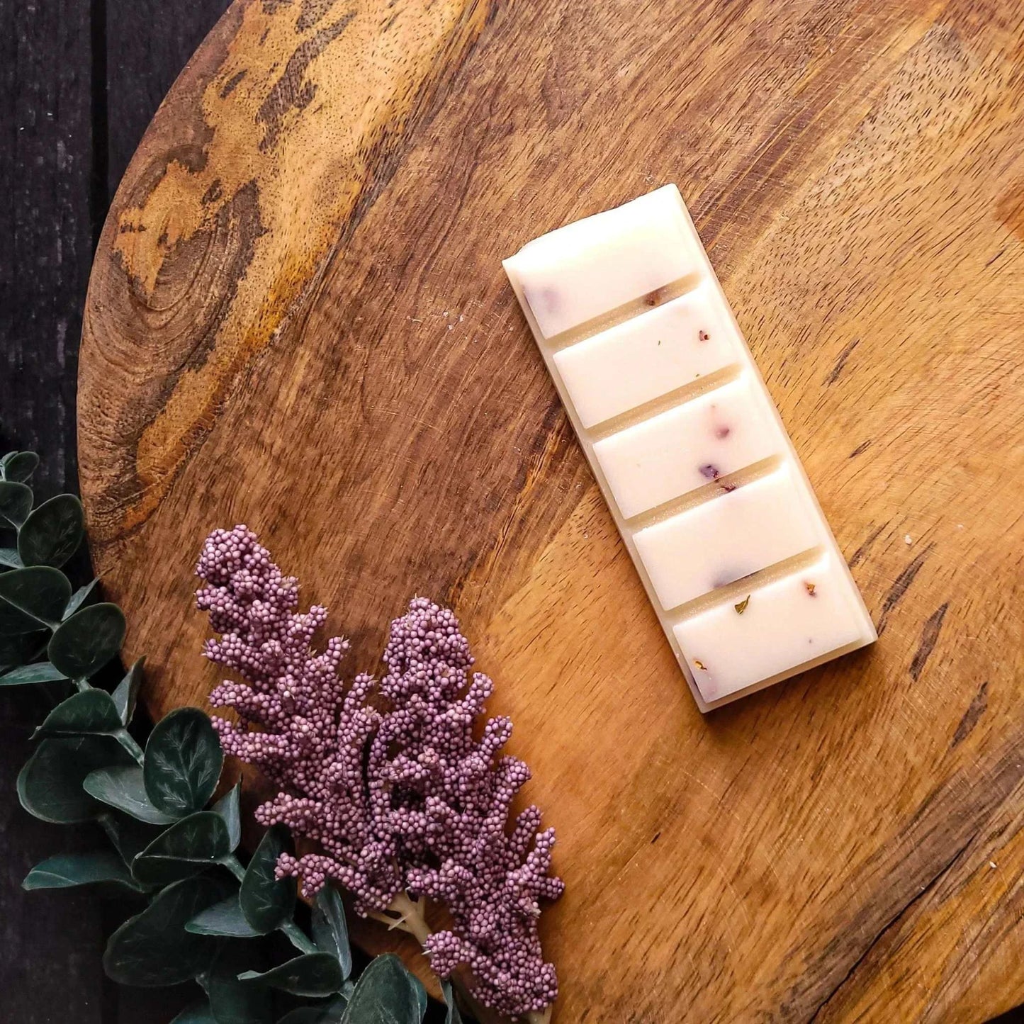 Lychee & Rose Waxmelt on wooden surface with greenery; lychee, rose, musk scented; soy wax blend.