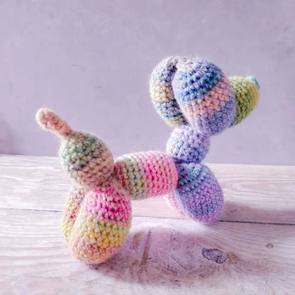 Rainbow balloon dog amigurumi toy made from acrylic and wool blend yarn.