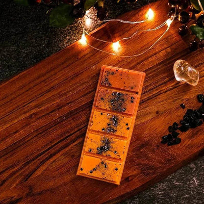 Halloween-themed Campfire Ghost Stories wax melt on a wooden board with lights.