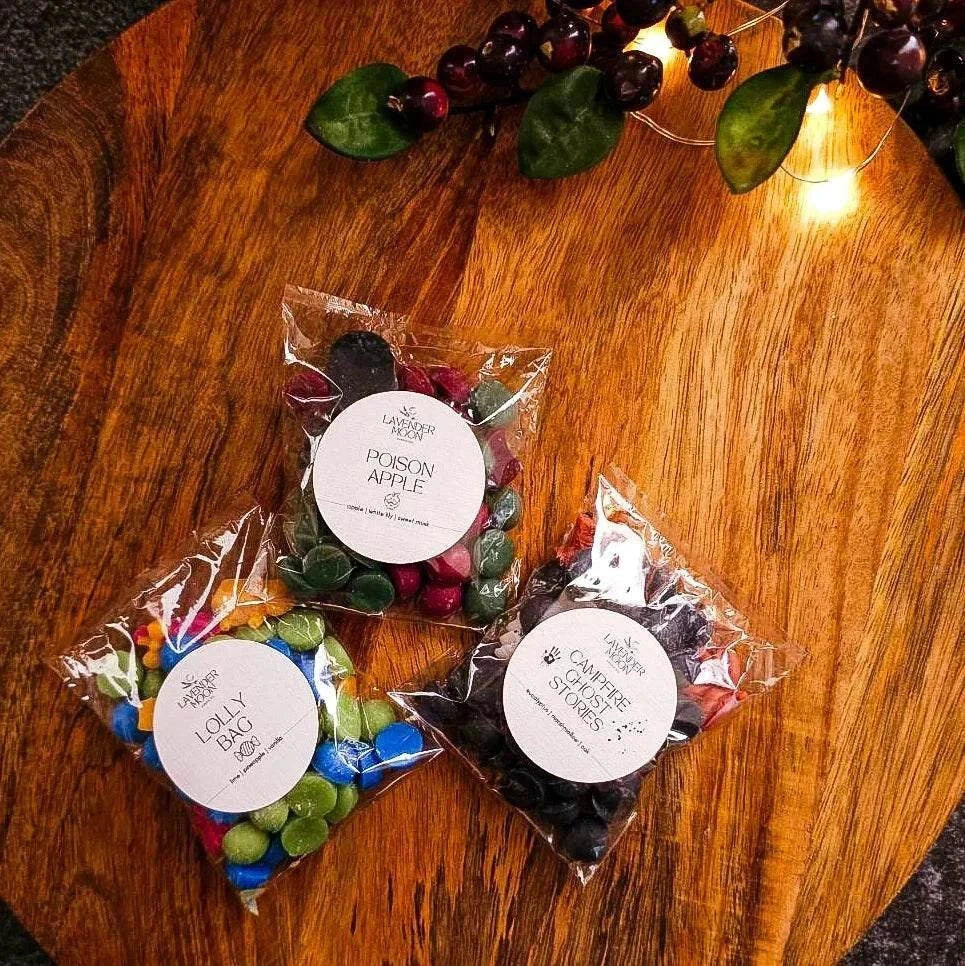 Halloween Shake & Melt Sampler Pack on wooden table with three 25g bags: Campfire Ghost Stories, Lolly Bag, Poison Apple.