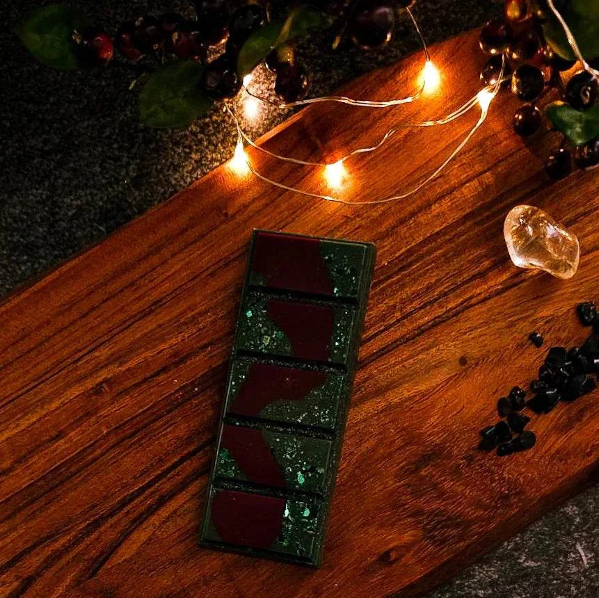Poison Apple Waxmelt on a wooden board with fairy lights and decorative elements.