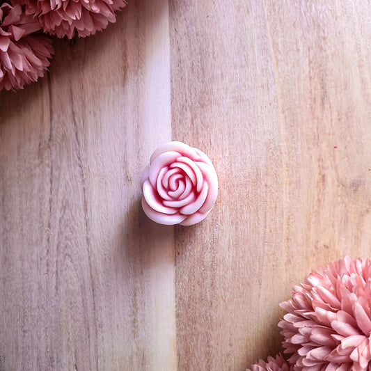 Sakura Rose Wax Melt on wooden surface with pink floral accents.