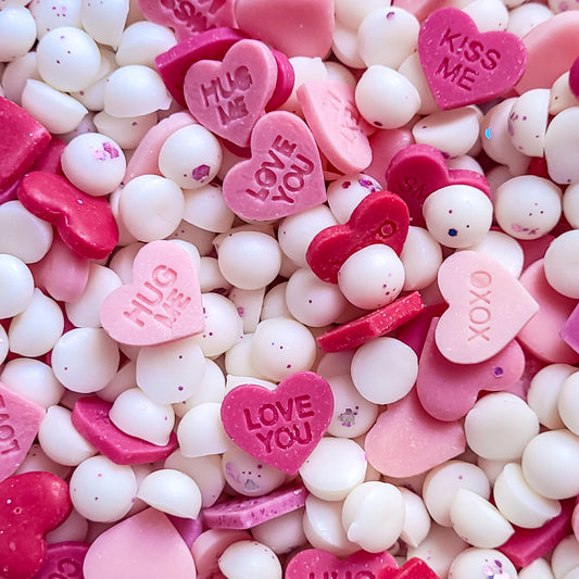 Valentine-themed wax melts with heart shapes and pink, red, white colors.